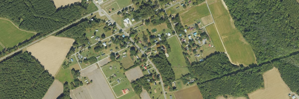 Aerial view of Kelford, its streets laid out on a grid among farm fields.