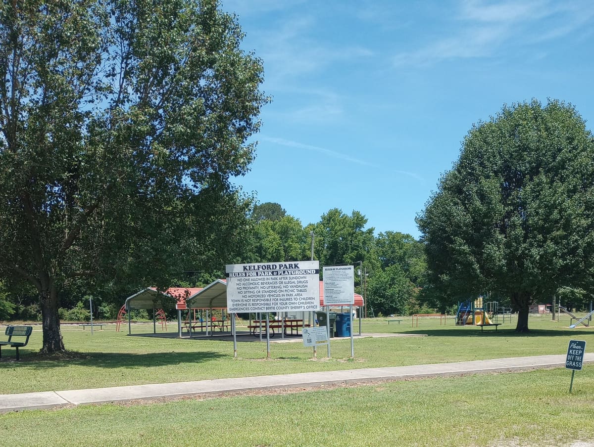 Kelford Park in summer, with its playground and picnic shelter under the trees.